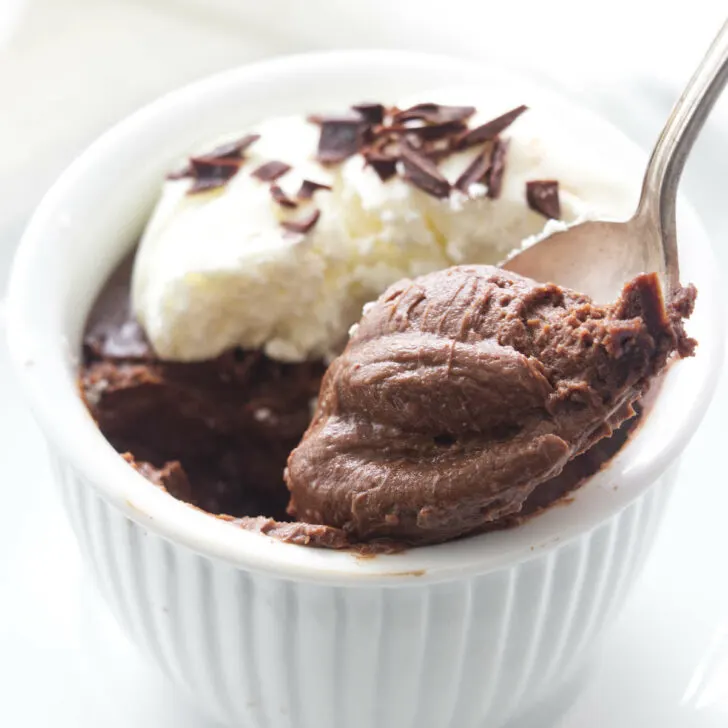 A serving of pots de creme with a spoonful being lifted from the dish.