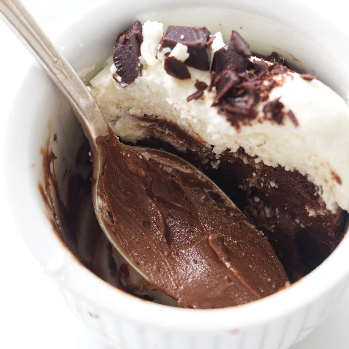 A serving of chocolate pots de creme with a spoon.