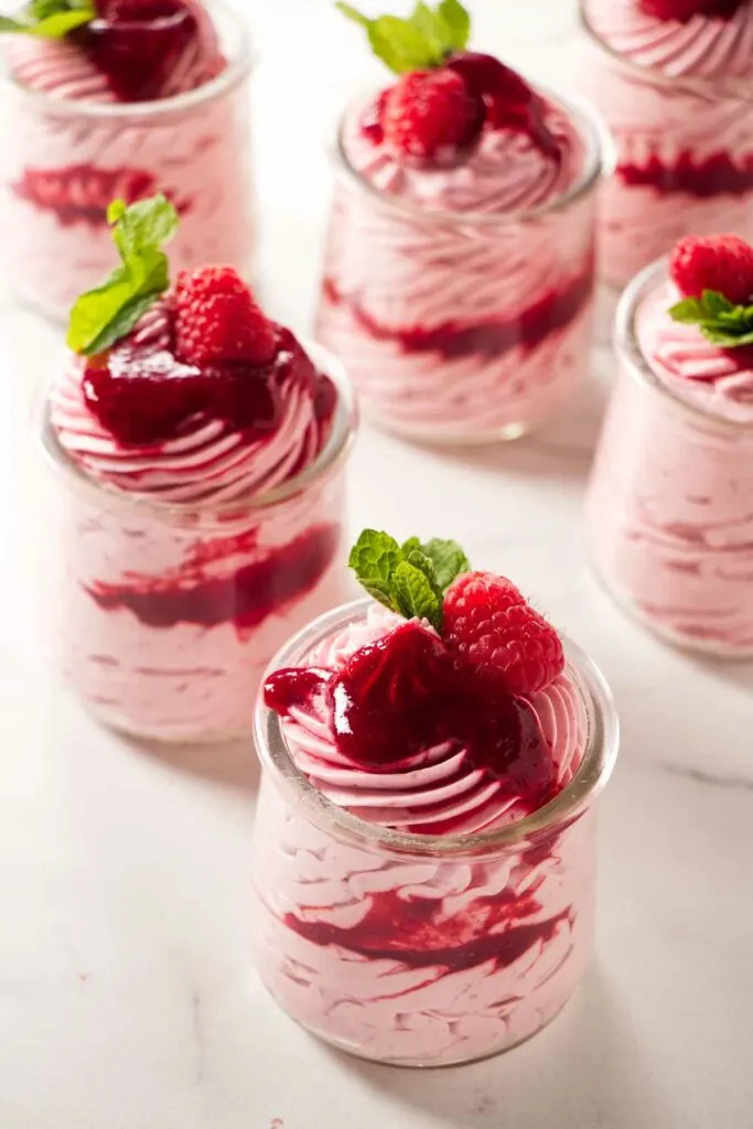Several parfait cups with raspberry mousse filling.