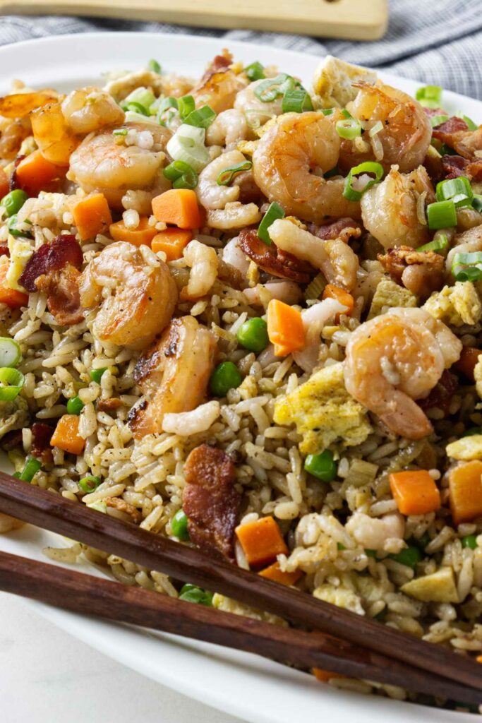 Shrimp fried rice on a platter with chopsticks.