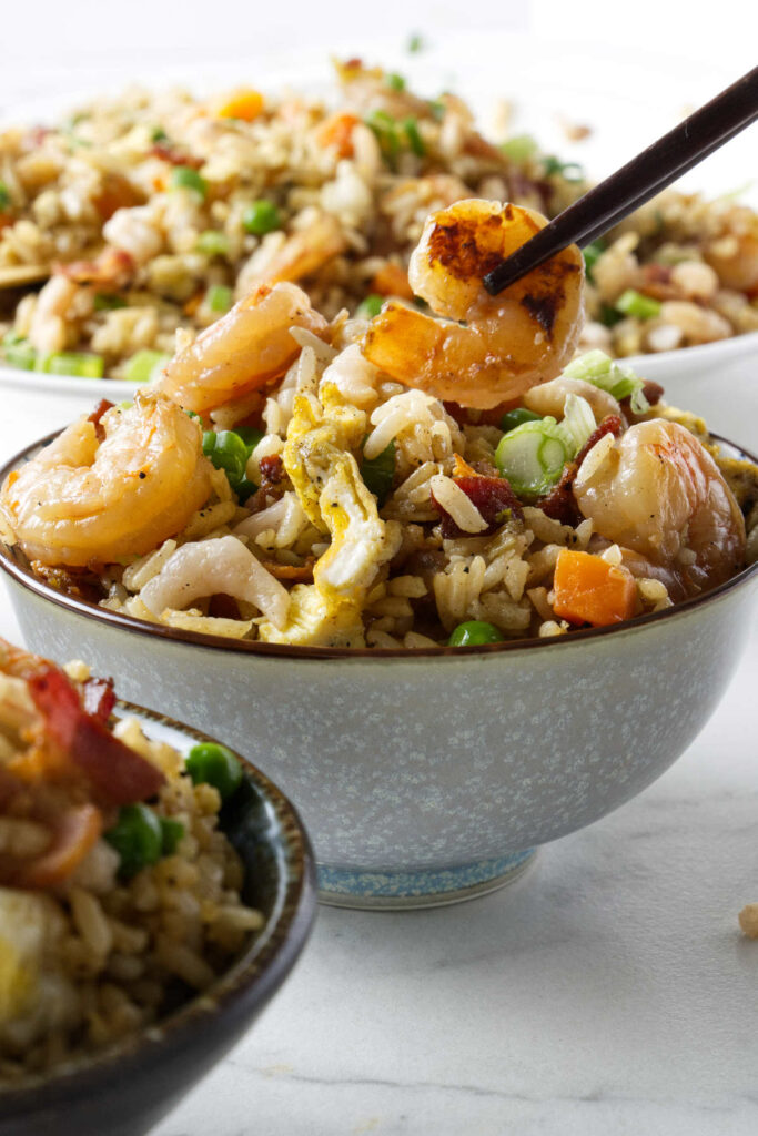 A bowl filled with fried rice with shrimp.