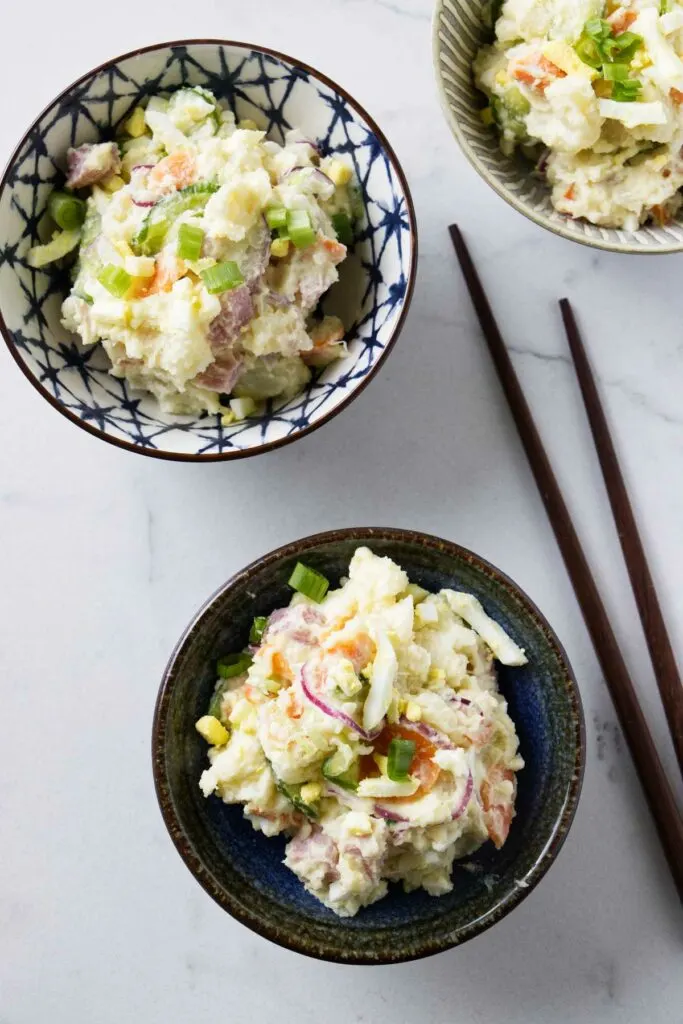 Small bowls of Asian potato salad next to some chop sticks.
