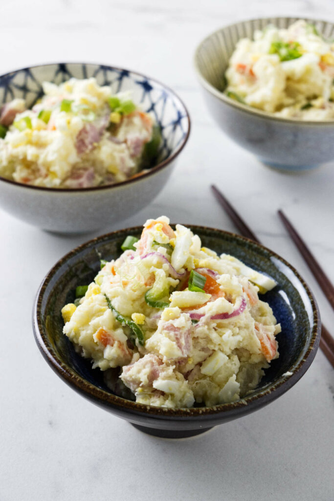 Three dishes filled with Japanese mashed potato salad.