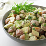 A bowl of red potato salad with yogurt dressing.