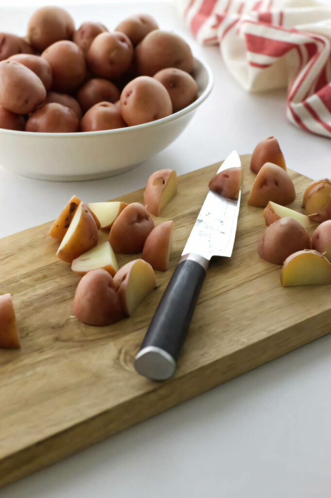 Slicing red potatoes on a cutting board.