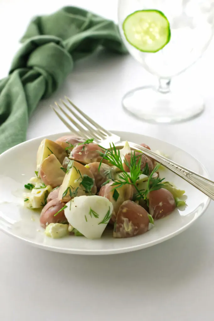 A plate with a serving of baby red potato salad.