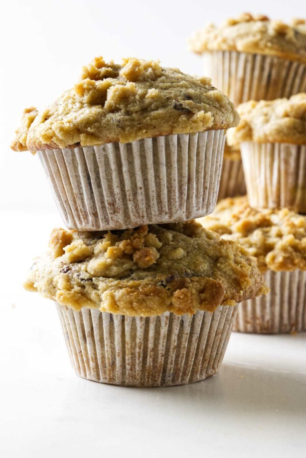 Sourdough discard banana muffins stacked on top of each other. One has chocolate chips.