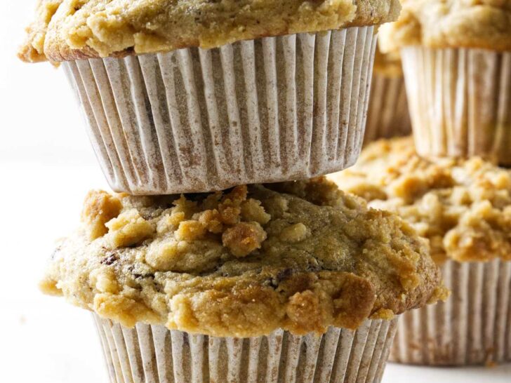 Sourdough discard banana muffins stacked on top of each other. One has chocolate chips.