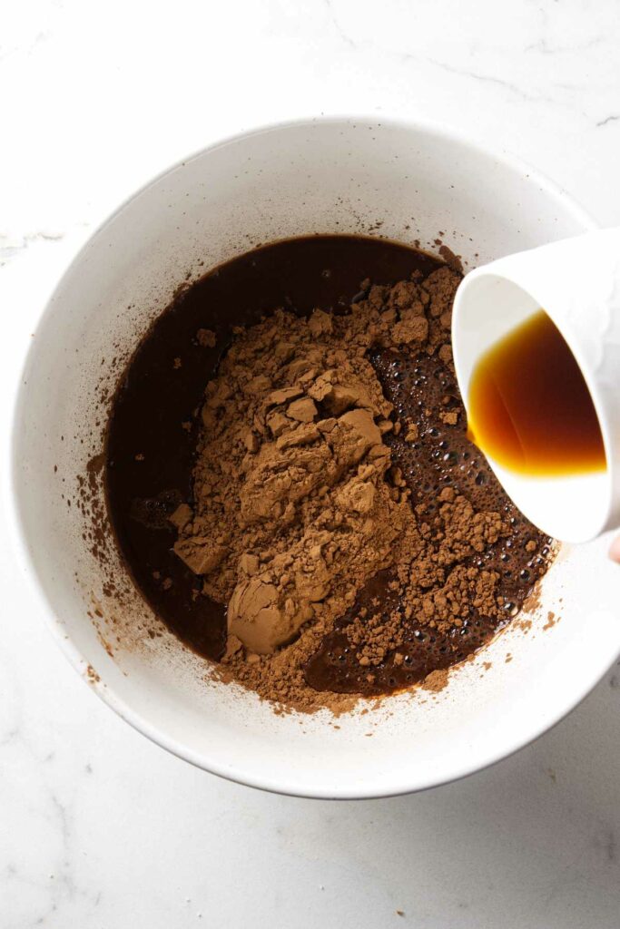 Pouring hot coffee into a bowl with unsweetened cocoa powder.