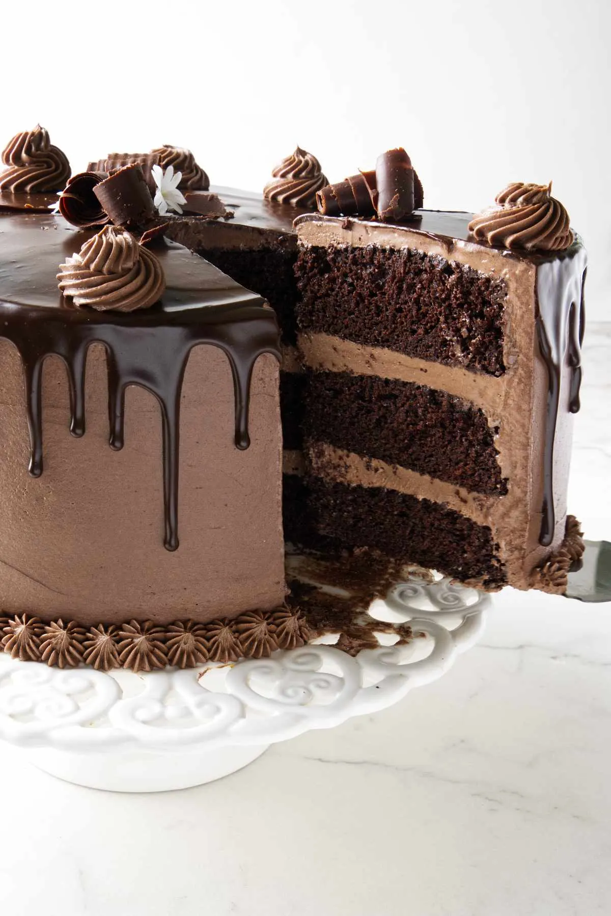 Serving a slice of a triple layer chocolate cake.