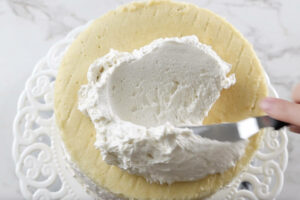 spreading frosting on the cake.