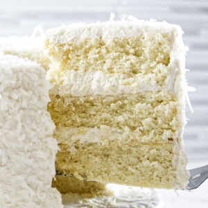 A slice of a three layer coconut cake.