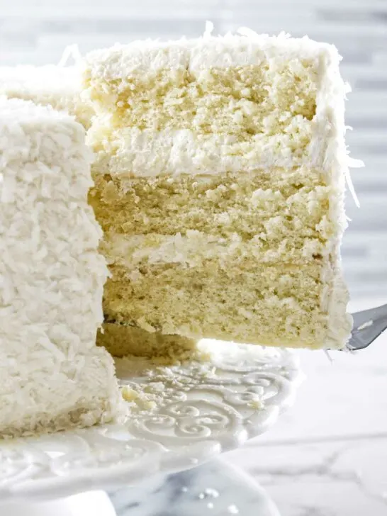 Lifting a slice of coconut cake from serving platter.