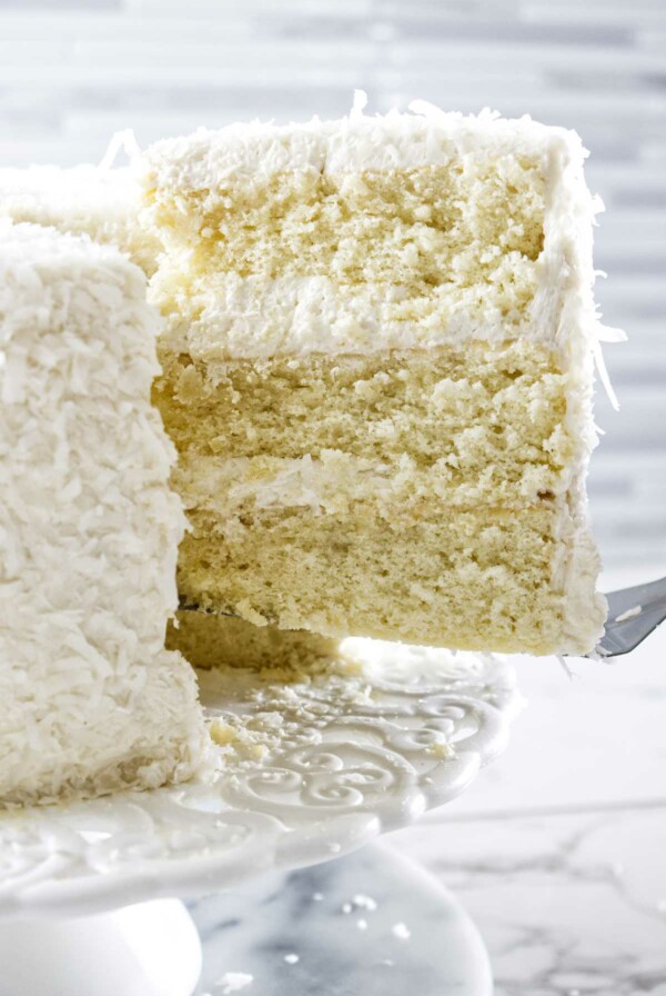 Lifting a slice of coconut cake from serving platter.