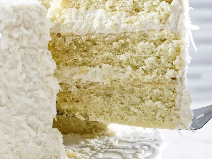 Lifting a slice of coconut cake from serving platter.