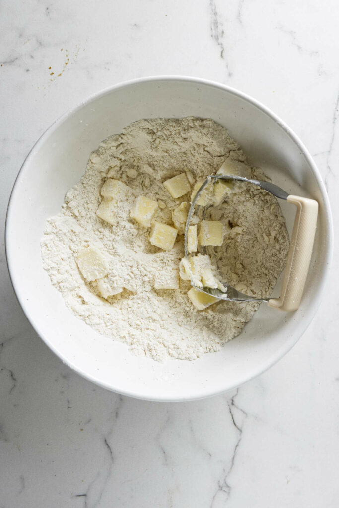 Cutting butter into flour to make pie dough.