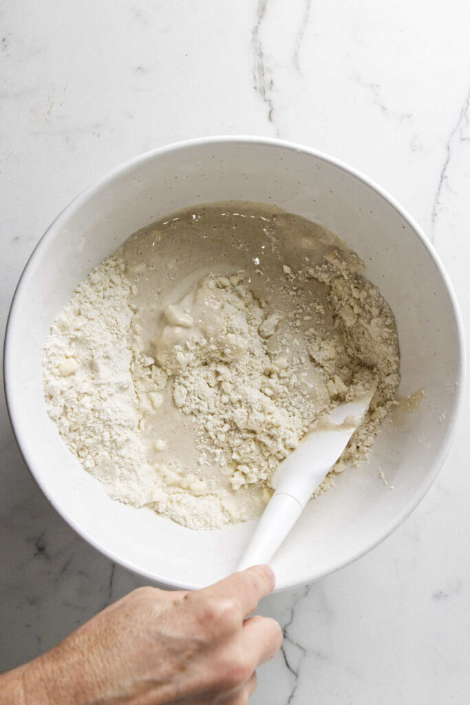 Stirring sourdough discard into pie dough.