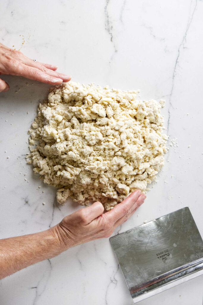 Pushing sourdough pie dough together after mixing the sourdough discard into the flour.