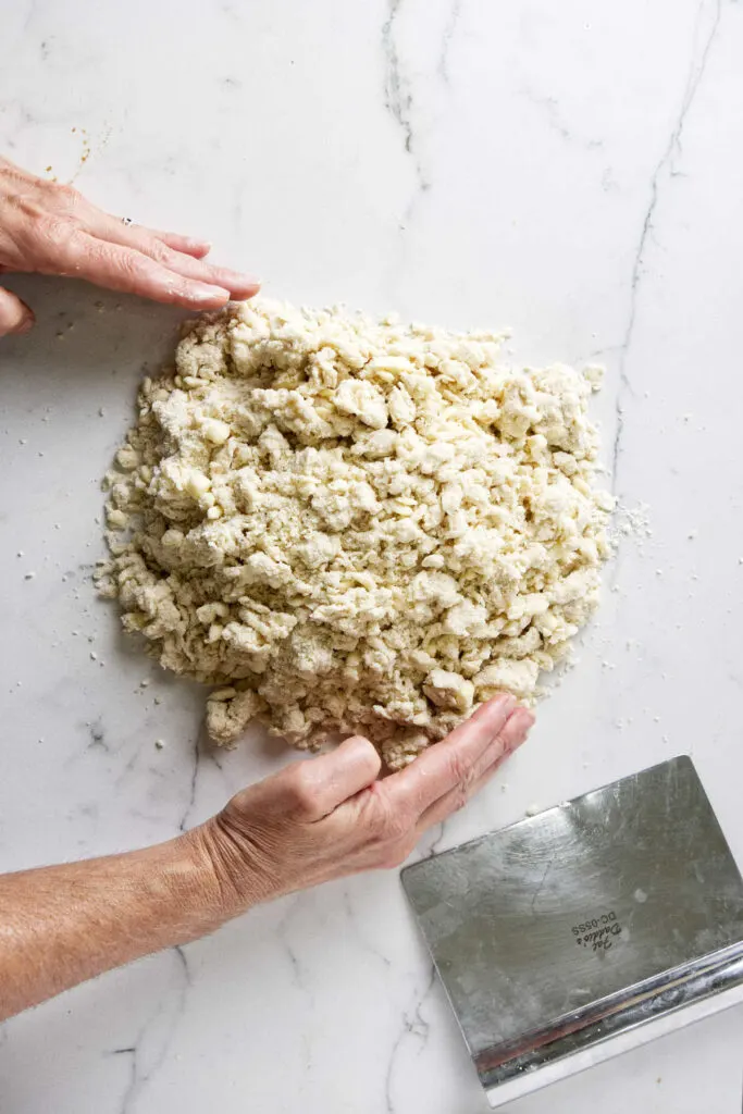 Pushing sourdough pie dough together after mixing the sourdough discard into the flour.