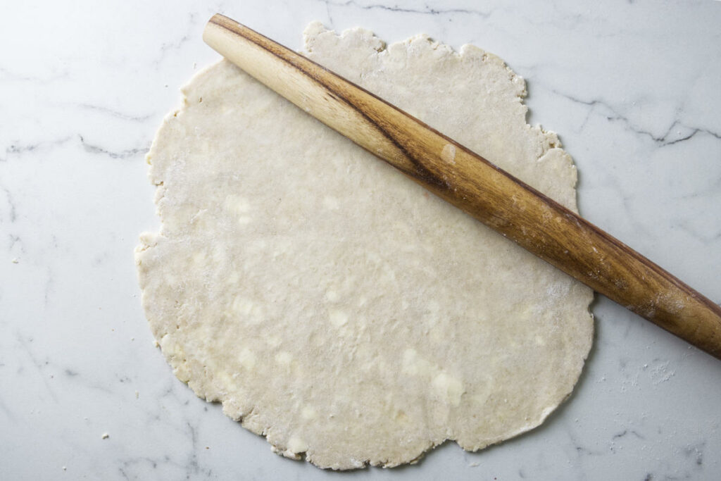 Rolling a sourdough pie crust out with a French roller.