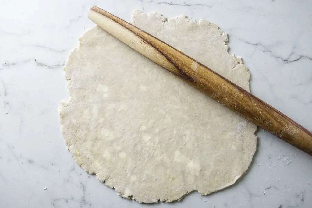 Rolling a sourdough pie crust out with a French roller.