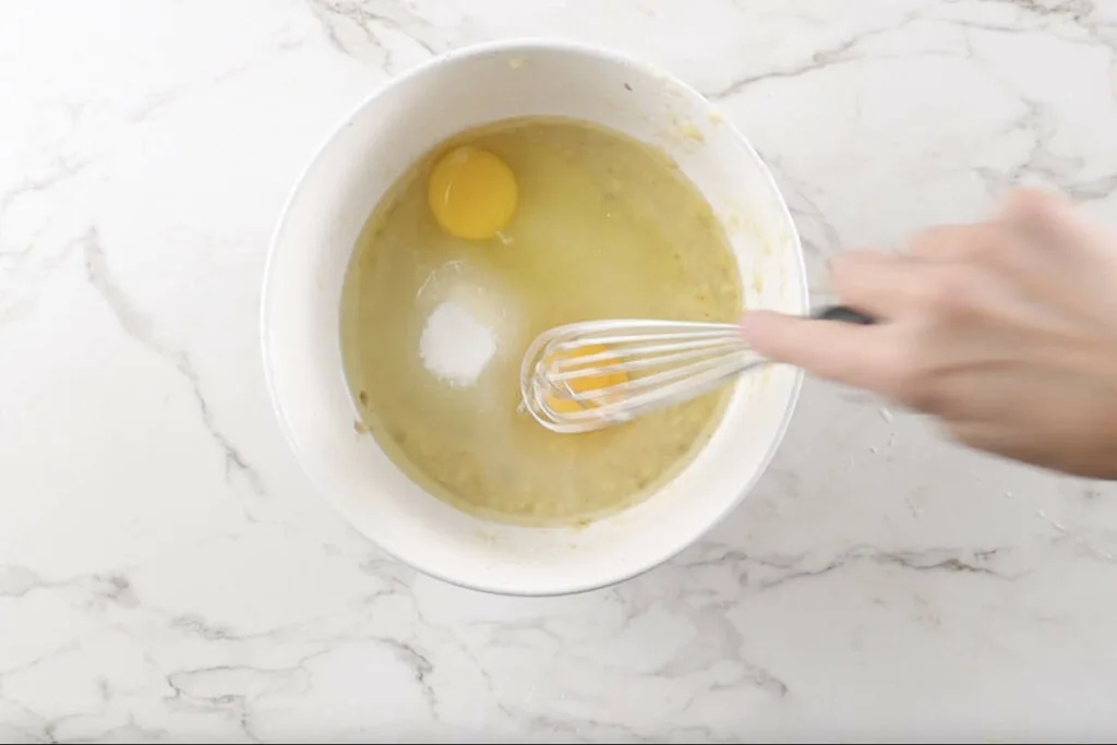 Stirring eggs into banana bread batter.