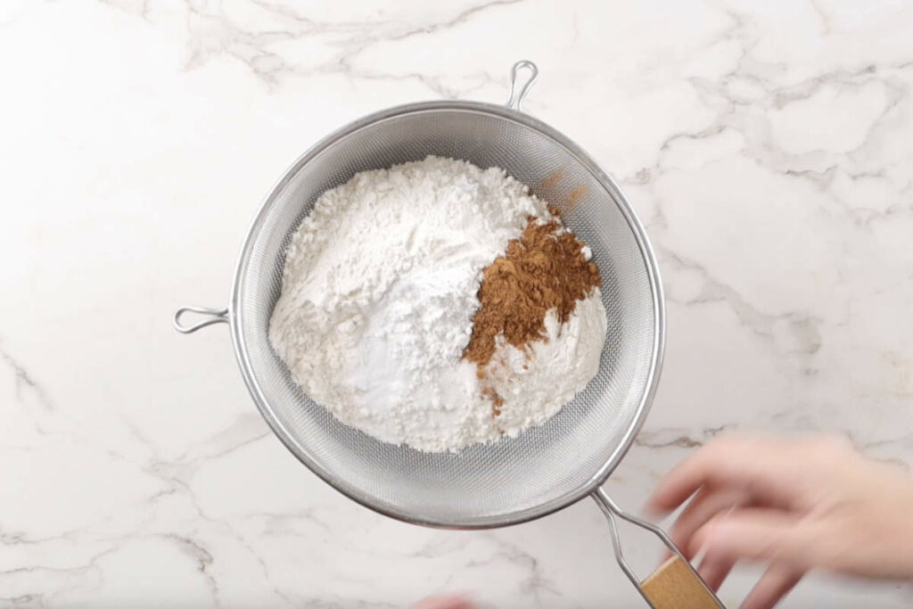 Sifting flour into the batter for banana bread starbucks recipe.