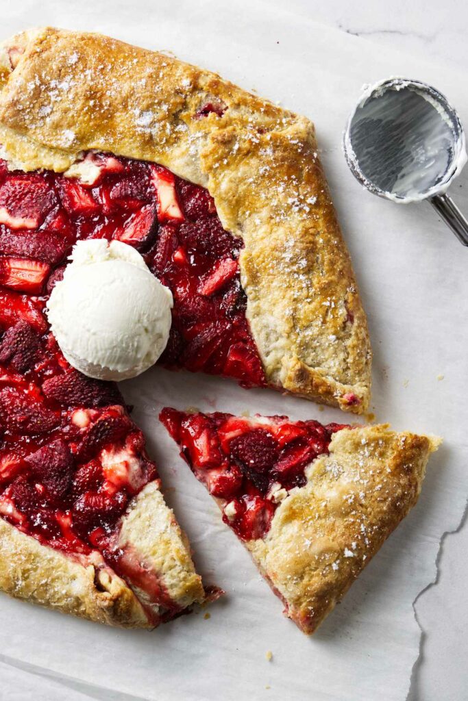 A slice taken from a galette with strawberries and cream cheese filling.
