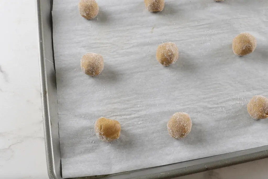 Balls of dough on a cookie sheet.