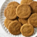 Several homemade gingersnap cookies on a plate.