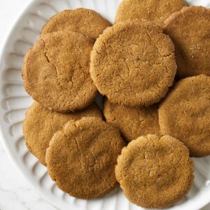 Several homemade gingersnap cookies on a plate.