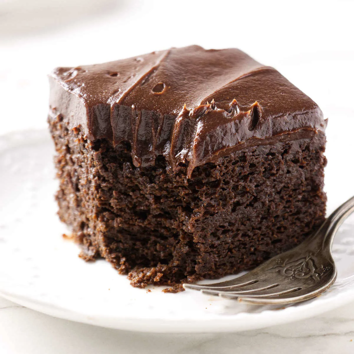 A slice of einkorn chocolate cake on a plate.