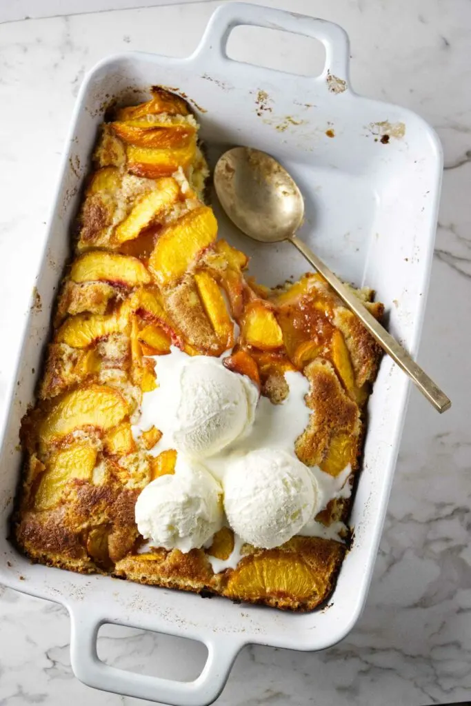 A warm old fashioned peach coffee cake in a baking dish.