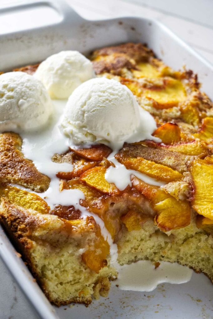 A peach coffee cake in a white baking dish.