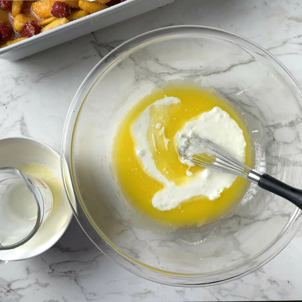 Whisking the eggs, sugar, and buttermilk.