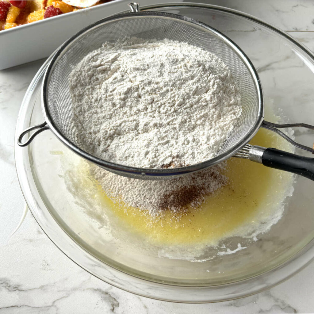 Adding the flour mixture to the spiced biscuit dough.