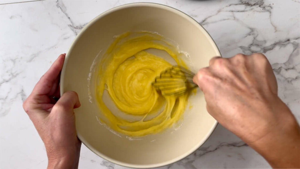 Mixing the eggs and sugar to make apple loaf bread.