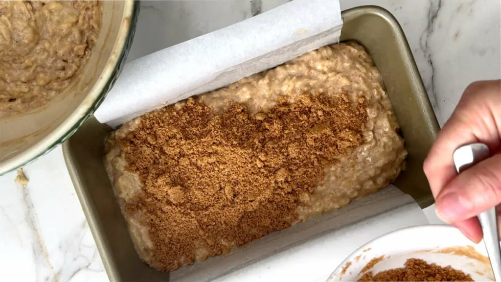 Adding cinnamon sugar in the center of an apple bread.