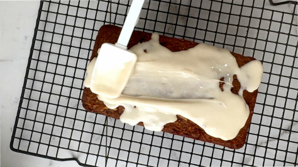 Spreading maple syrup on top of apple bread.