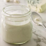 A jar filled with cottage cheese blue cheese salad dressing.