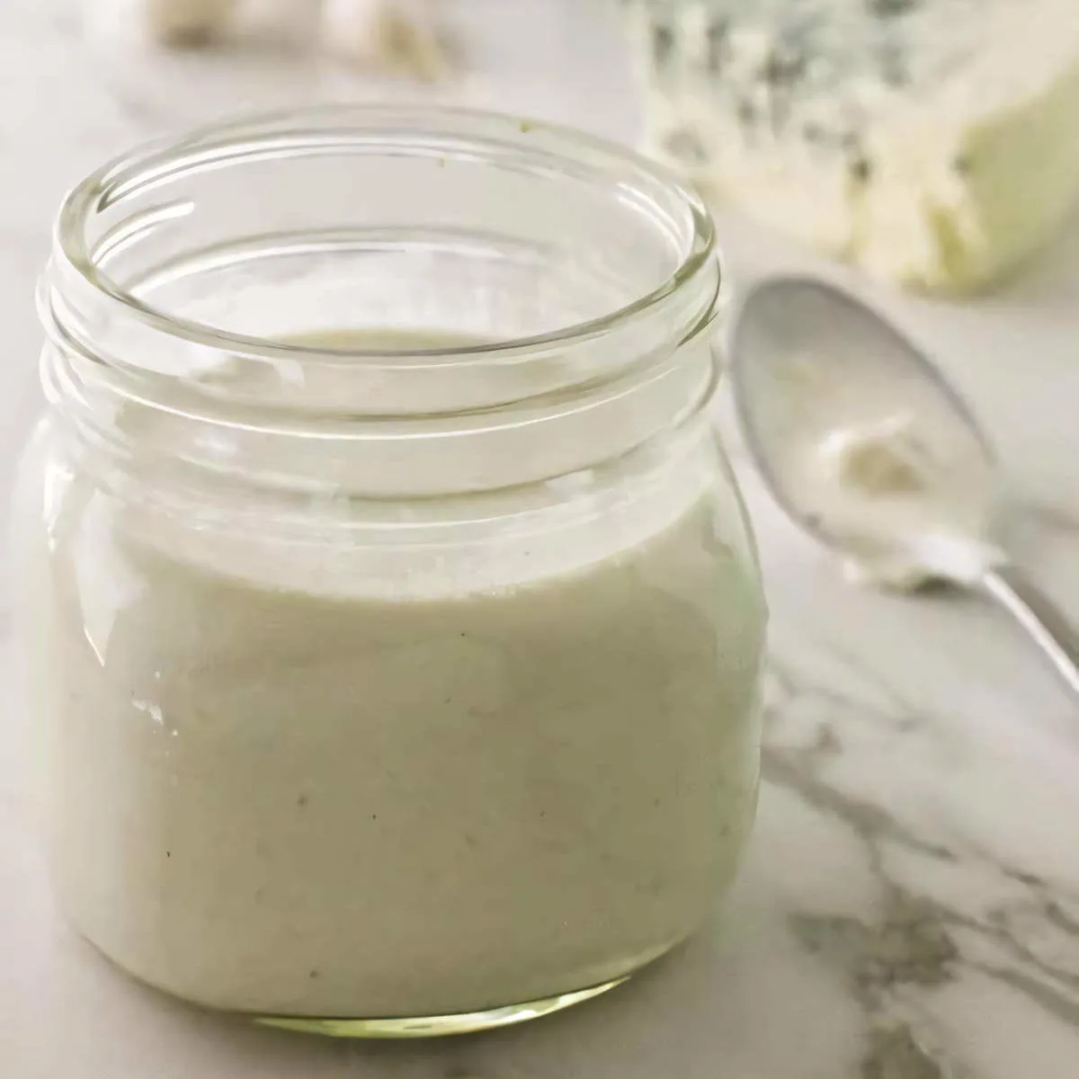 A jar filled with cottage cheese blue cheese salad dressing.