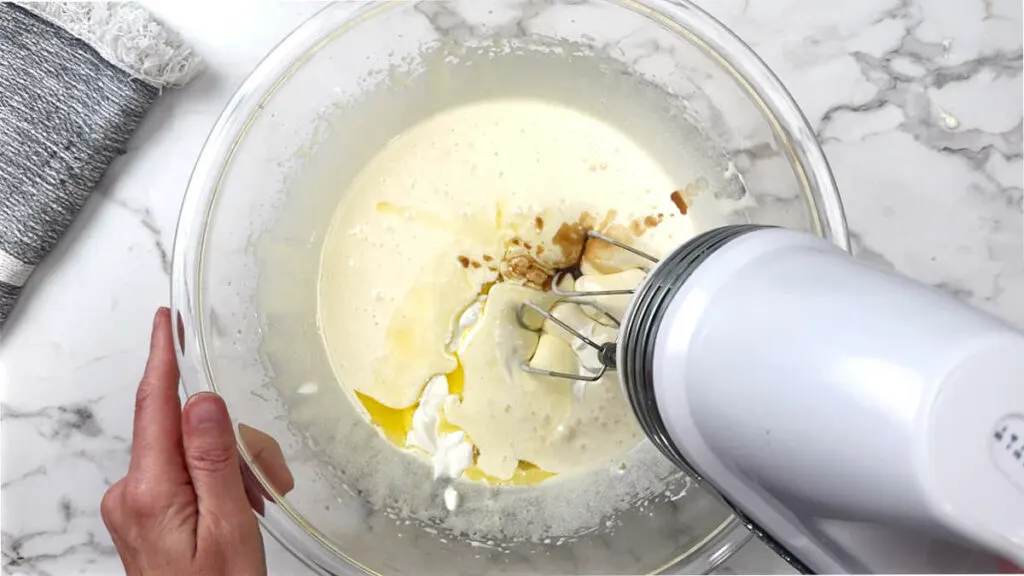 Blending sour cream into the mixture for a pear cake recipe.