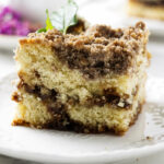 A slice of sourdough discard coffee cake with a cinnamon swirl.