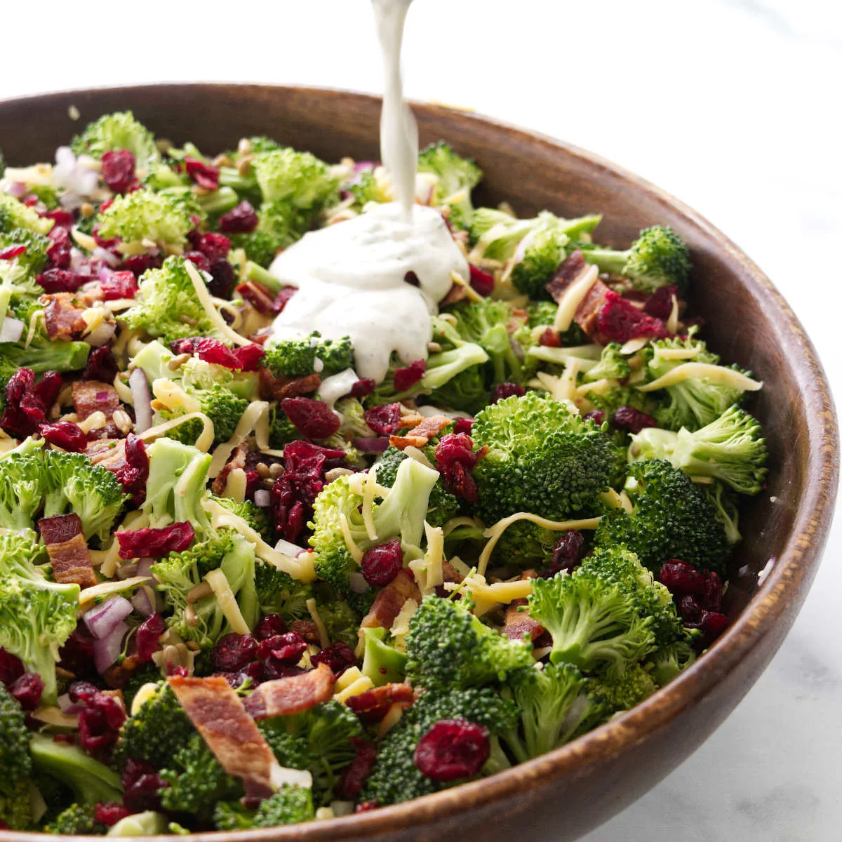 Pouring dressing on a bowl of salad.