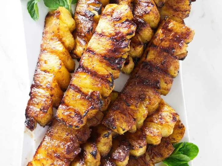 A serving platter with slices of cinnamon grilled pineapple.