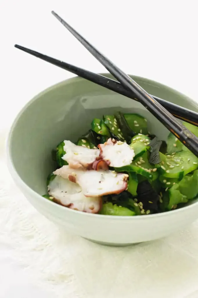 A Japanese cucumber salad in a bowl with chopsticks.