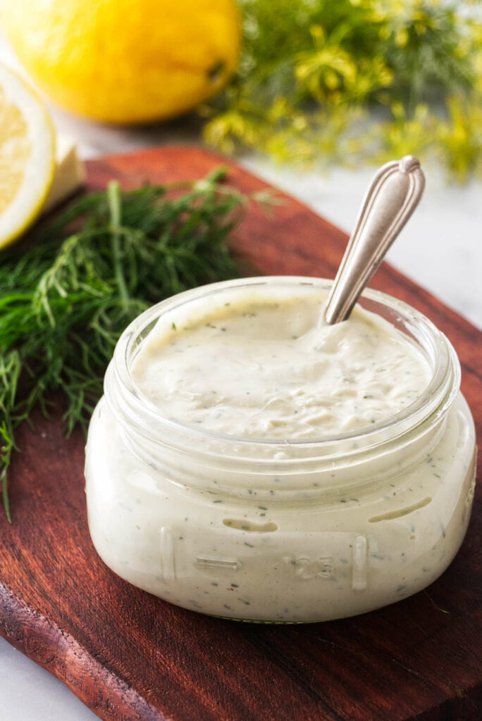 A spoon in a jar of homemade lemon dill aioli.