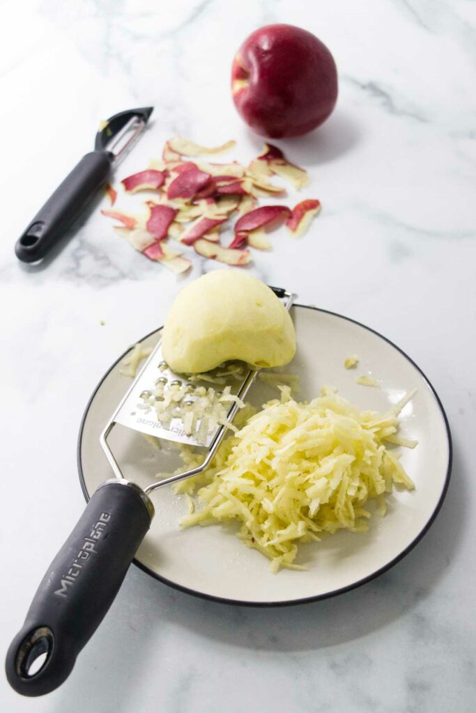 Grating apples for cake batter.