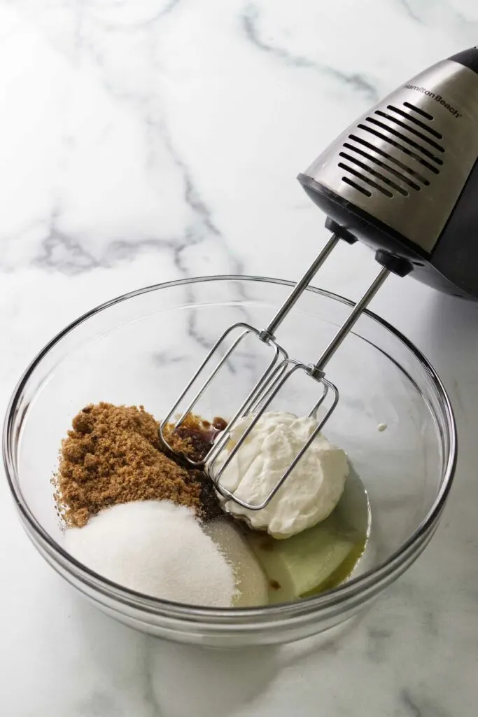 Combining the wet ingredients for mini apple cakes.