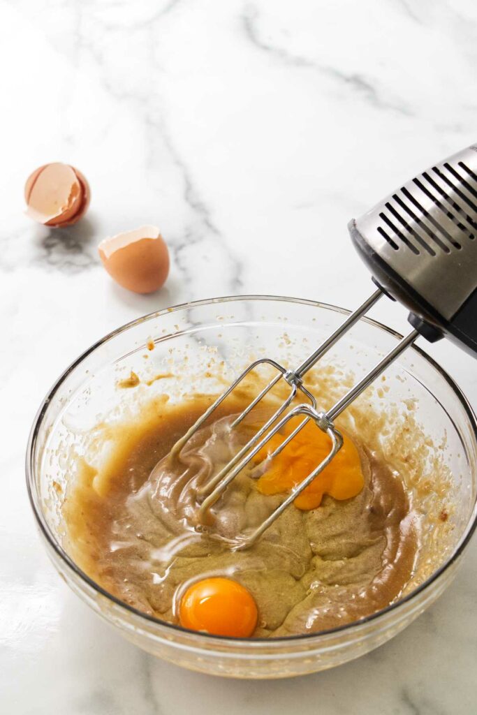 Adding eggs to the batter.